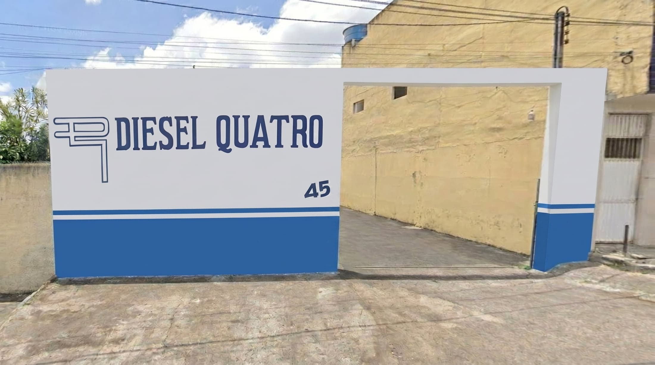 Muro azul e branco da oficina, com o letreiro DIESEL QUATRO pintado e o número 45